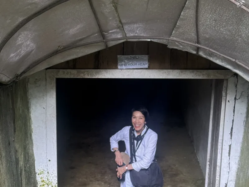 Traveler at a cave entrance in Laos, illustrating Brother Tours exploration around Konglor Cave.